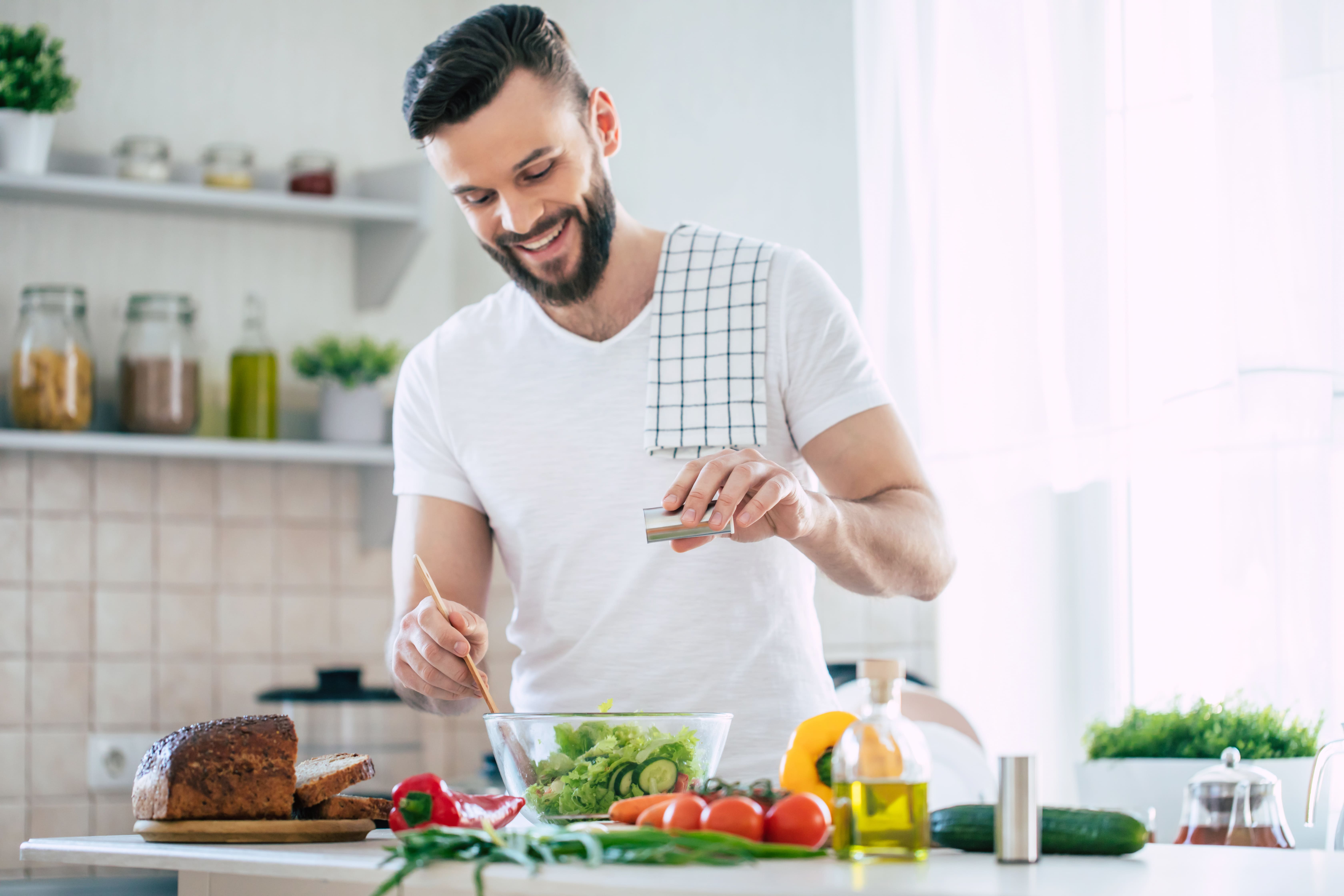 man is preparing wonderful fresh vegan salad